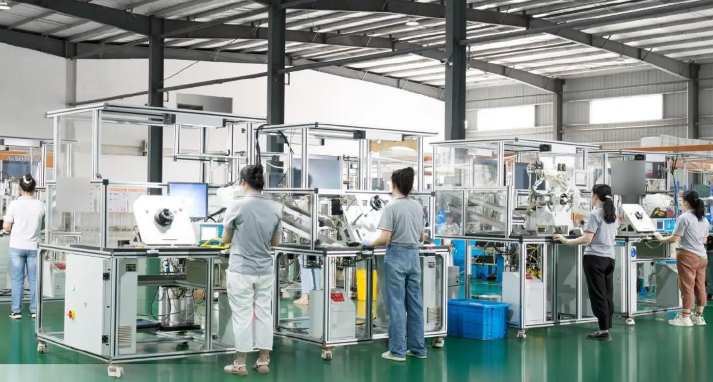 Workers operating enclosed testing equipment in a selected clock spring program